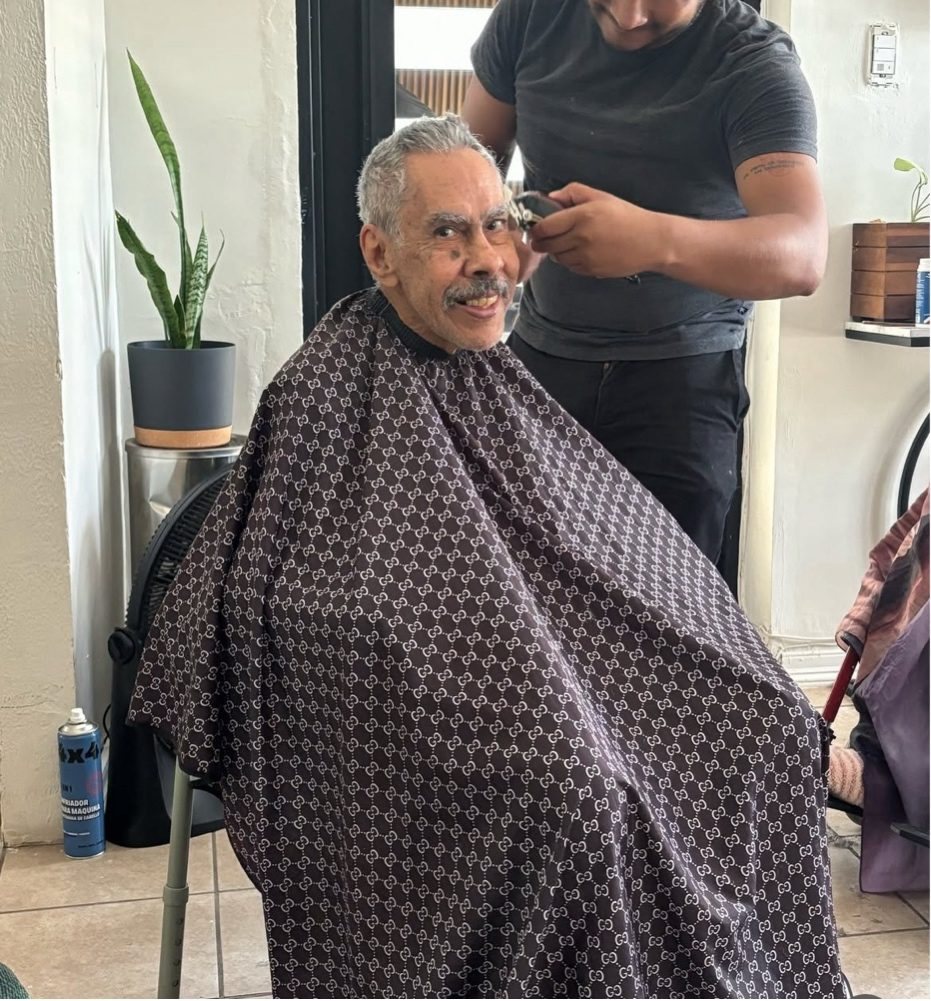 Un residente sonríe durante su corte de cabello